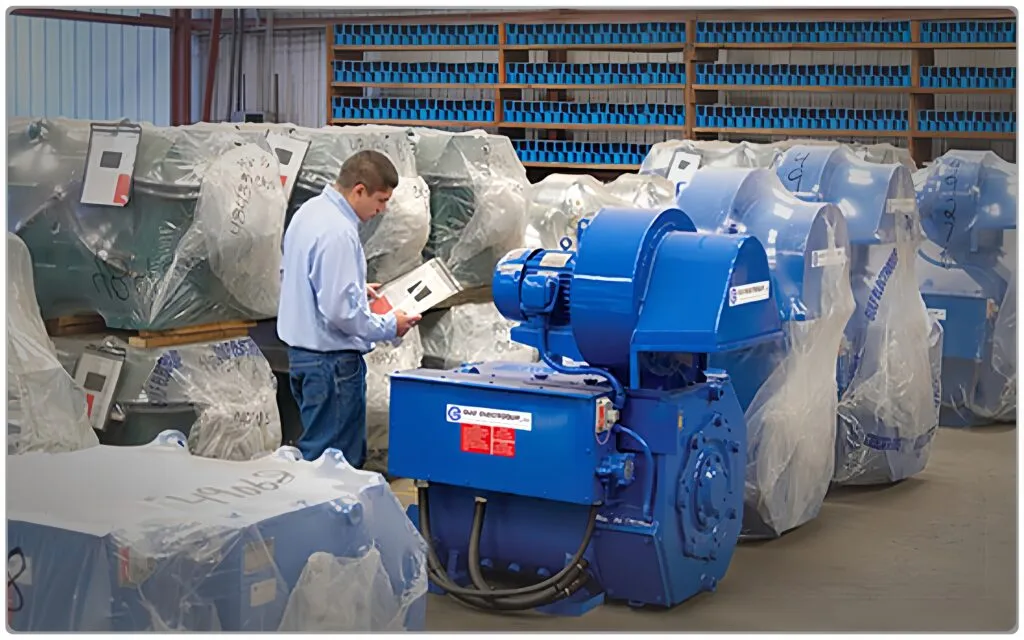 Technician reviewing electirc motors documentation as part of preventive maintenance record keeping in an industrial storage area